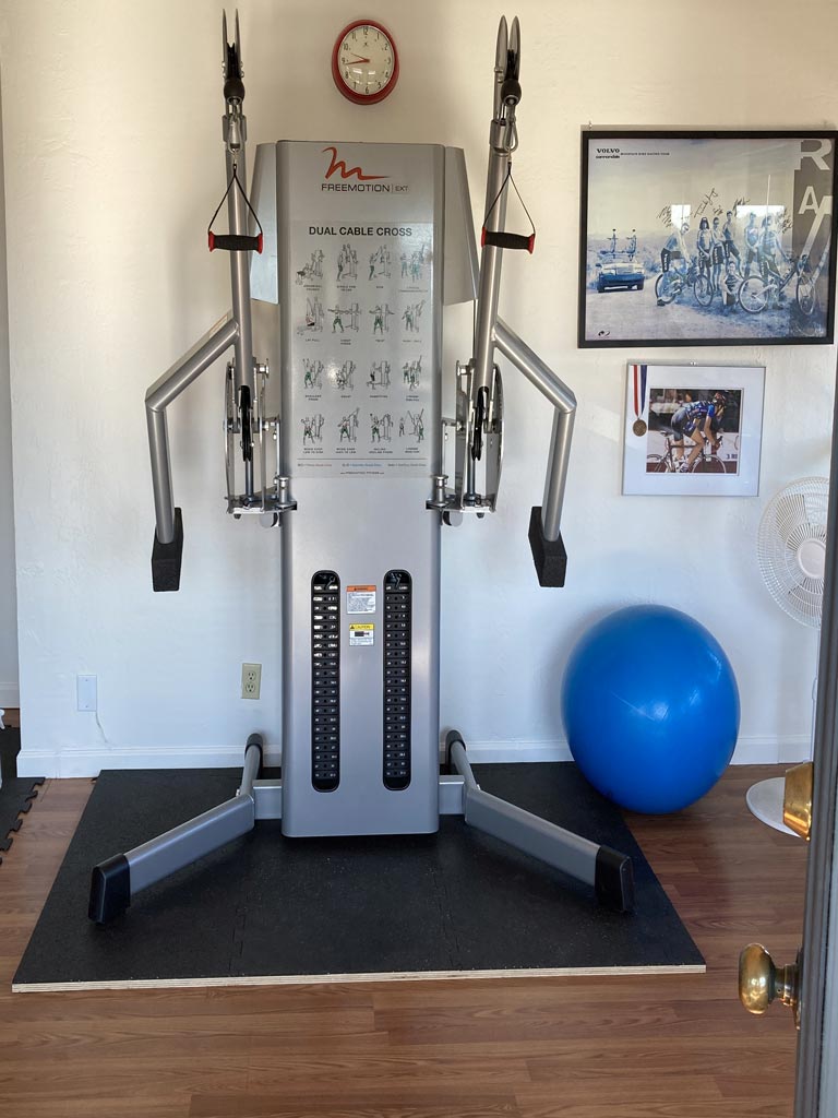 Ellis Fitness Studio - Dual Cable Cross Equipment with an exercise ball and framed images on the wall.